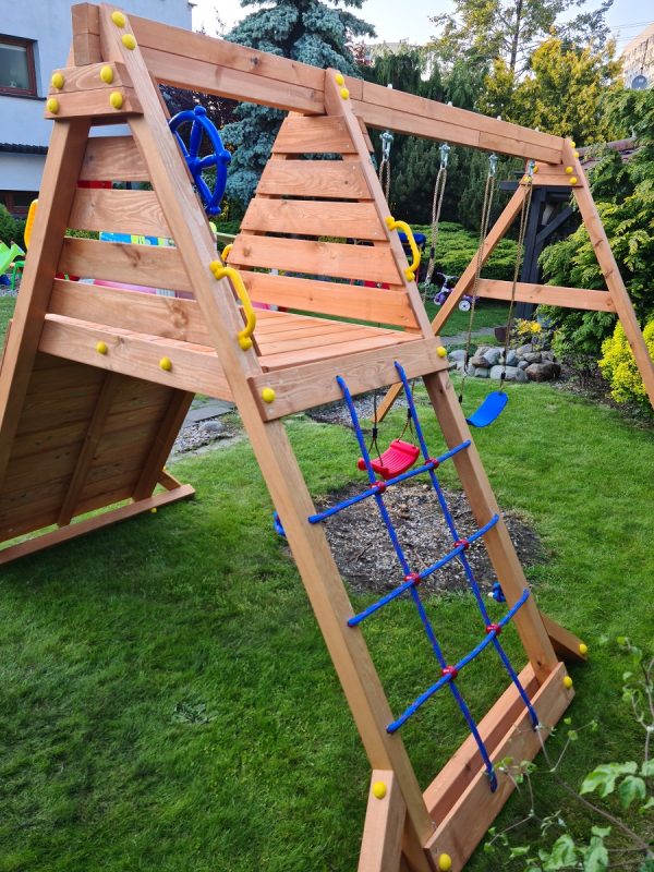 Wooden playground set with climbing wall, rope net, and two swings for kids, designed for safe and active outdoor play